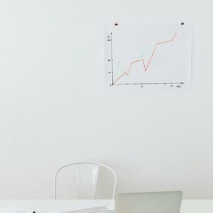 Clean desk setup with chart, laptop, and office supplies for analysis.